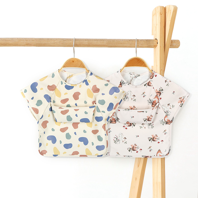 Babero de delantal de PU de manga corta con diseño de bolsillo para bebés